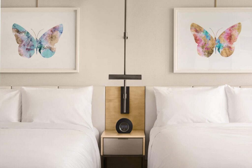 JW Parq Hotel luxury Vancouver bhotels bedroom with two beds and paintings